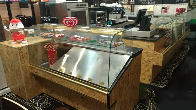 Balcão de madeira com vitrine de vidro, máquina de café e torradeira