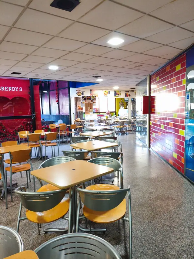Praça de alimentação do Centro Comercial D. Dinis com mesas junto à Docemania