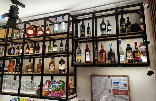Garrafeira de ferro preto com vinhos, cervejas e licores portugueses